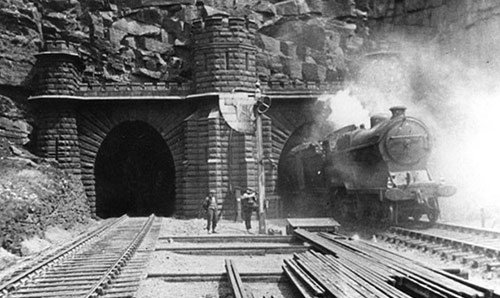 Black and white photograph of a train exiting a tunnel, courtesy Tameside Archives. 