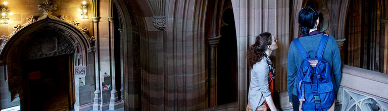 Students standing in the archways of John Rylands Research Institute and Library